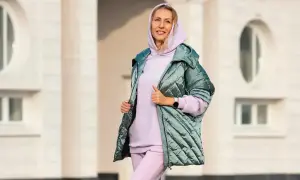 Kobieta w pastelowym dresie i pikowanej kurtce. Idealny zestaw, jak się ubrać na 15 stopni, by czuć się komfortowo i stylowo.