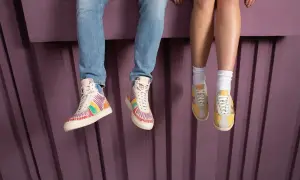 Kolorowe buty sneakersy i żółte, klasyczne sneakersy na nogach siedzących osób.