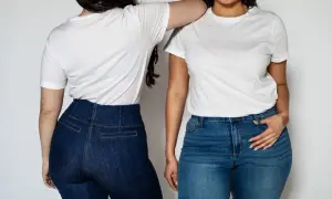 Dwie kobiety w białych T-shirtach i dżinsach. Jedna z nich ma podkreślone szerokie biodra.