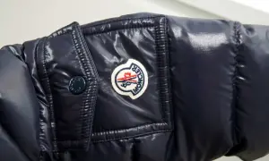 Granatowa, błyszcząca kurtka z naszywką Moncler. Czy to właśnie ta firma, o którą pytasz?