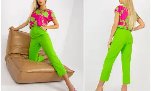Jaka bluzka do zielonych spodni? Modelka prezentuje stylizację z fuksjową bluzką w zielone liście i neonowe, zielone spodnie.