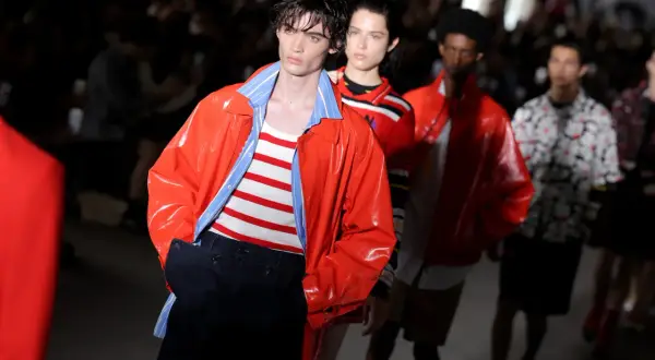 Model prezentuje pomarańczową kurtkę i pasiasty top na pokazie MSGM. To właśnie MSGM co to za marka?