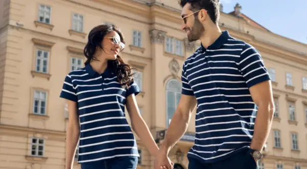 Para spaceru w koszulkach polo. Zobacz, jak nosić koszulka polo damska i męska w pasy, tworząc stylowy duet.