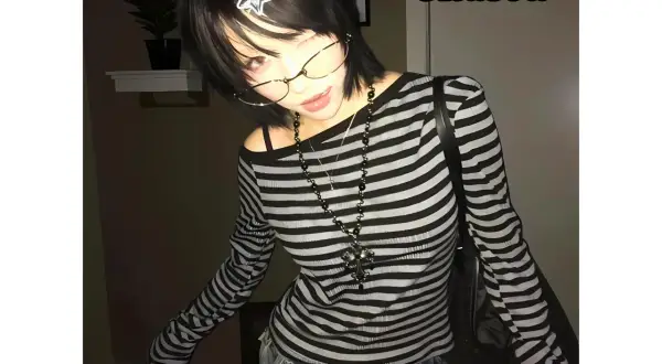 Dziewczyna w stylu y2k grunge, w bluzce w paski i okularach, z gwiazdką we włosach.