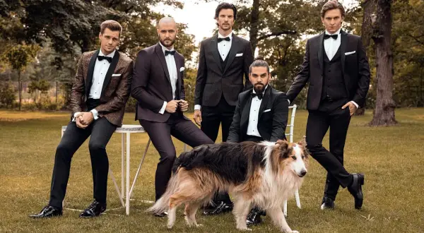 Eleganccy panowie w smokingach i stylowe buty do smokingu, towarzyszy im pies.