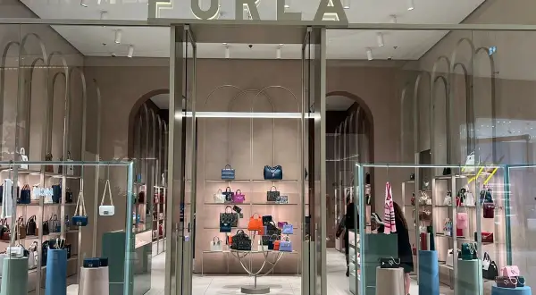 Elegancki butik Furla, gdzie furla co to za marka jest widoczna na szyldzie. W środku mnóstwo torebek i akcesoriów.