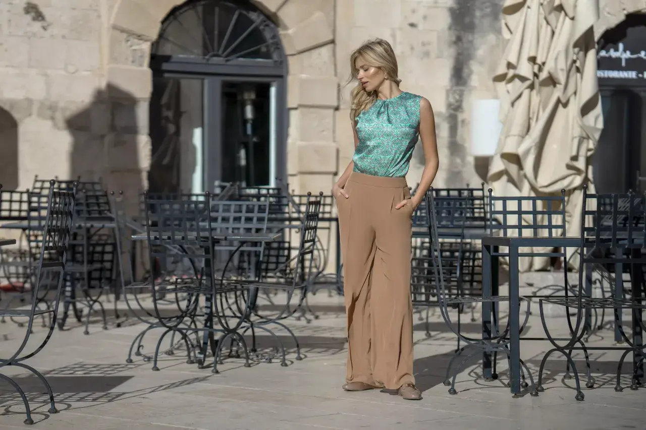Elegancka stylizacja na wieczór panieński: zielona bluzka w delikatny wzór i beżowe, szerokie spodnie. Idealna na letnie wyjście.