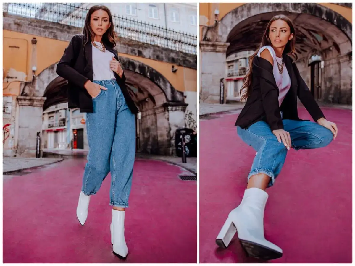 Stylowa kobieta w spodniach mom jeans, białych botkach i czarnej marynarce. Inspiracja na czym nosić spodnie mom mom jeans stylizacje.
