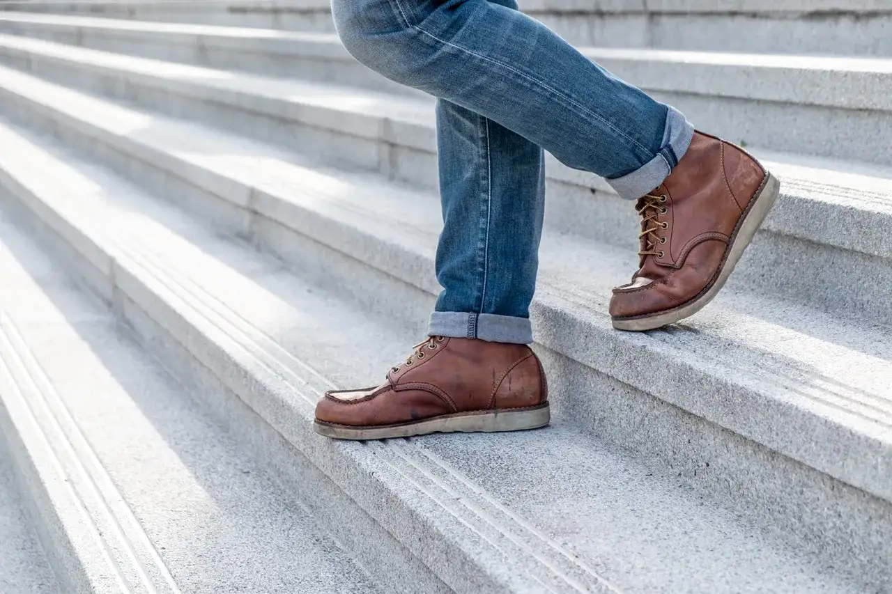 Męskie buty do jeansów: brązowe sznurowane botki na schodach. Idealne połączenie stylu i wygody.