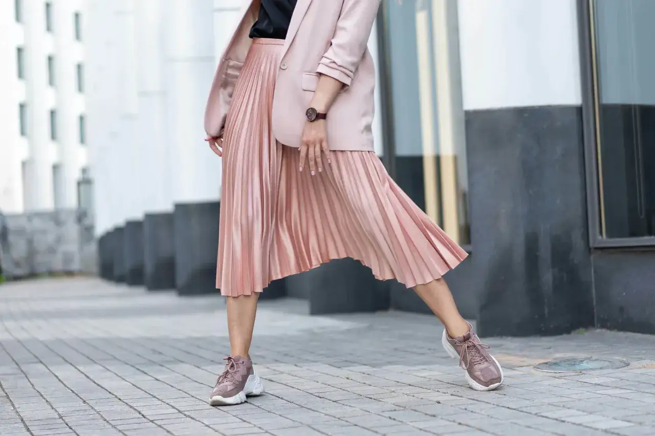 Różowa spódnica plisowana w stylizacji z marynarką i sneakersami. Idealna na co dzień i na specjalne okazje.